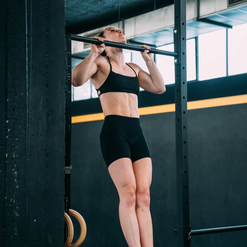Abbey Willis pulling into a muscle up on a bar